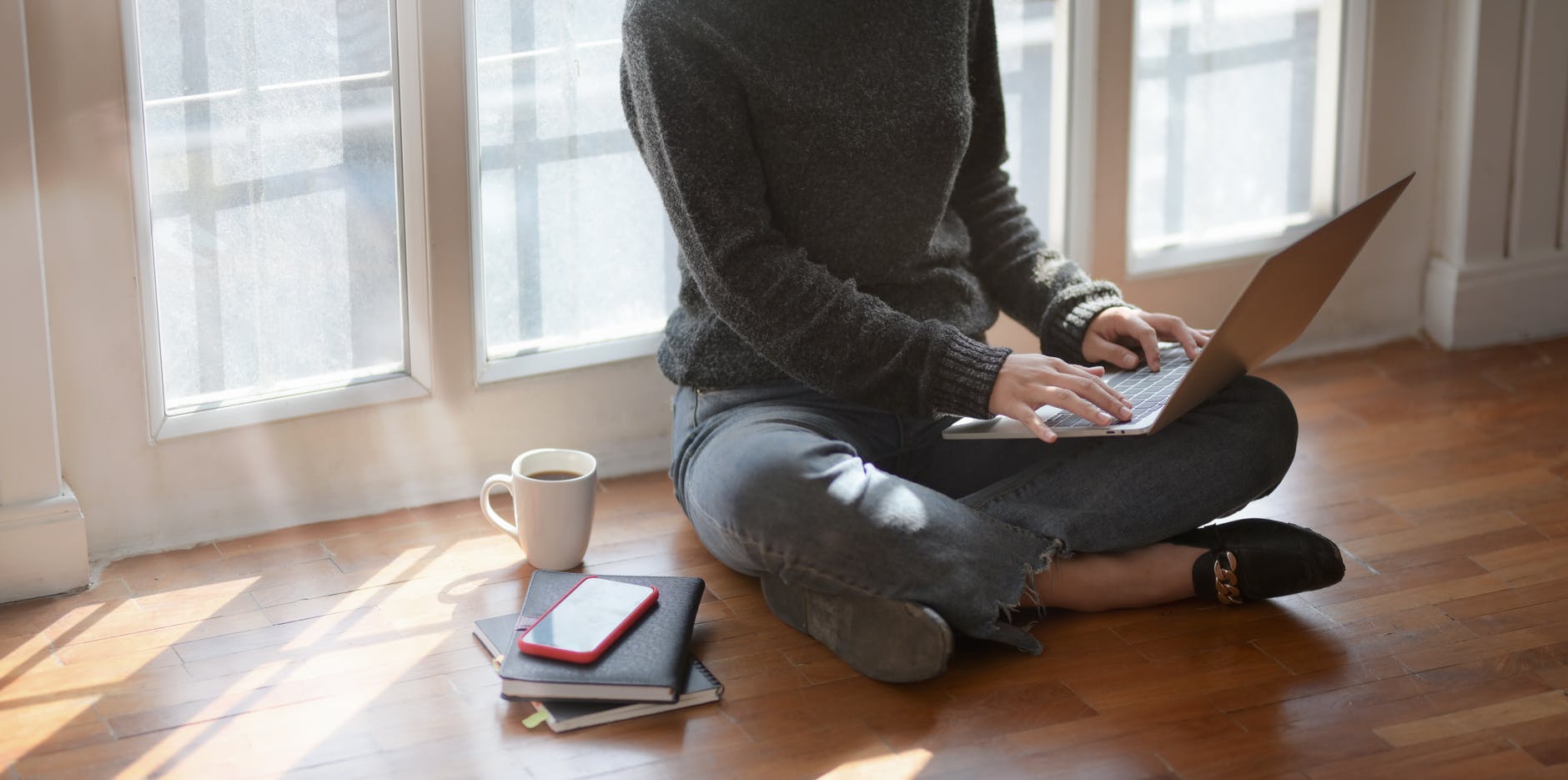 woman in gray sweat shirt sitting beside window